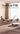 A couple are doing yoga, while Honiture T10 Robot Vacuum is cleaning the floor